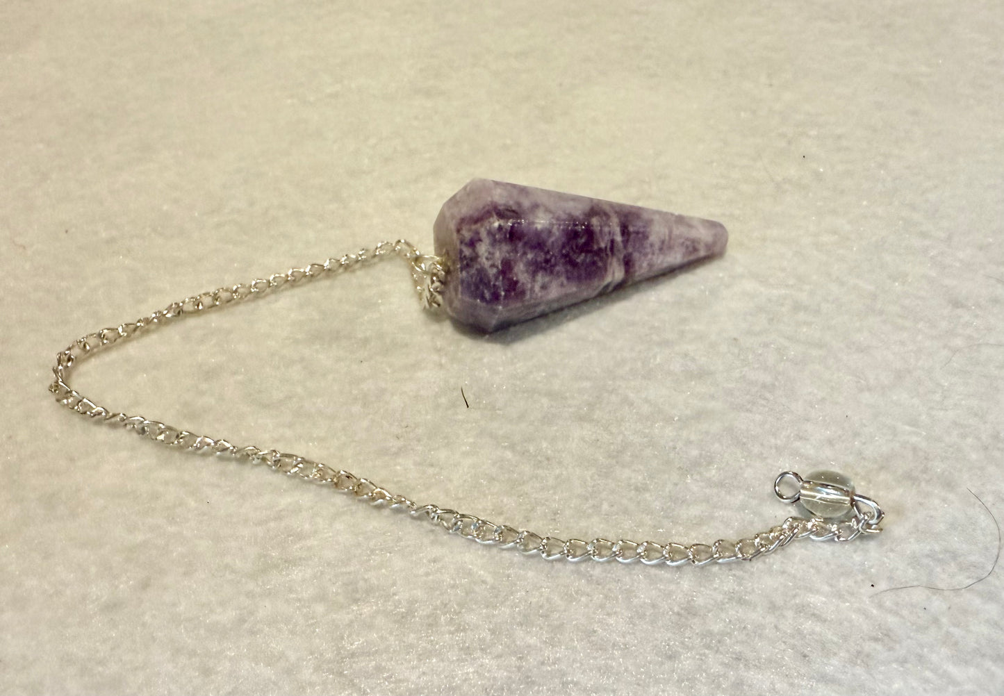 This pretty pink and purple Lepidolite Pendulum is  1.5” and with chain is 9”