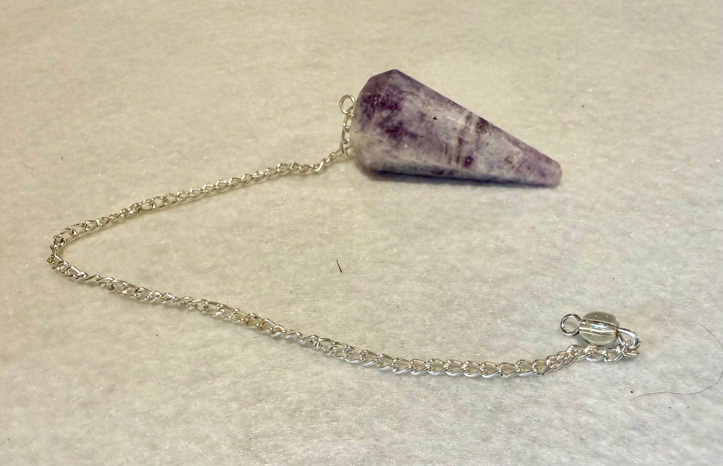 This pretty pink and purple Lepidolite Pendulum is  1.5” and with chain is 9”