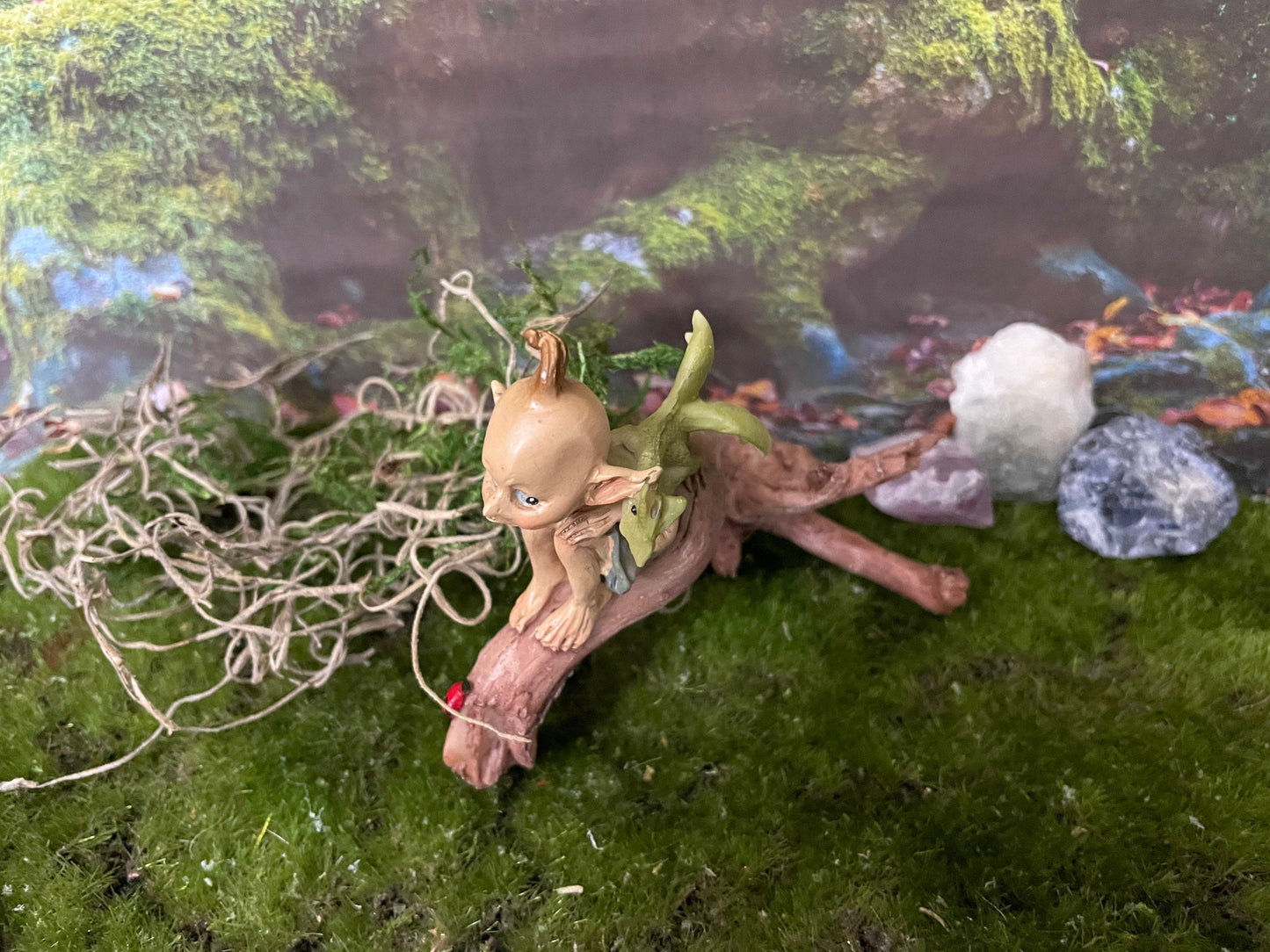 Pixie lovers garden pixie and baby green dragon perching on a log
