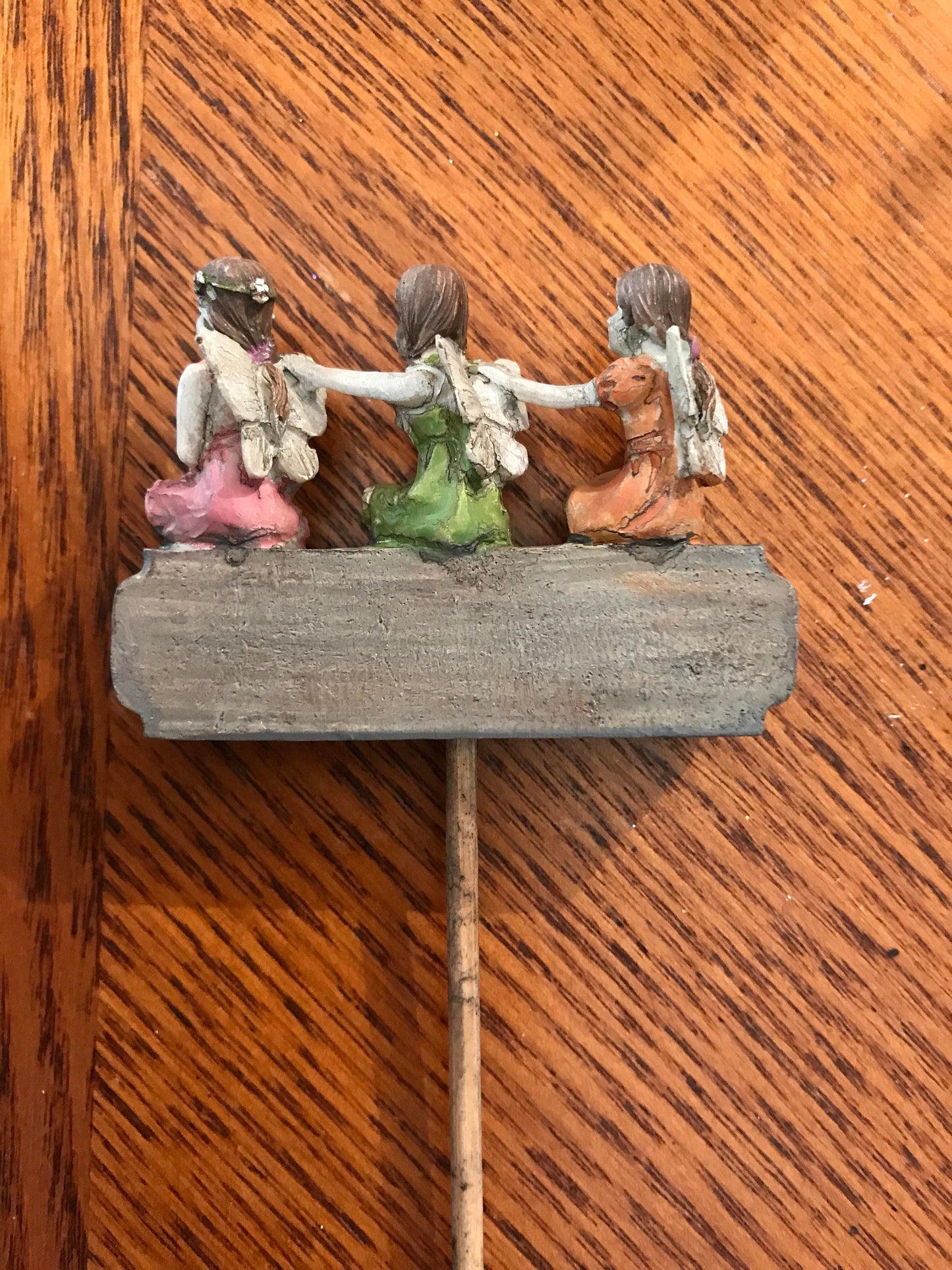 Three tiny fairies sitting upon a sign welcome you and your friends to your garden.