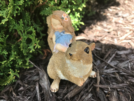 Little sleeping fairy on squirrel, outdoor garden