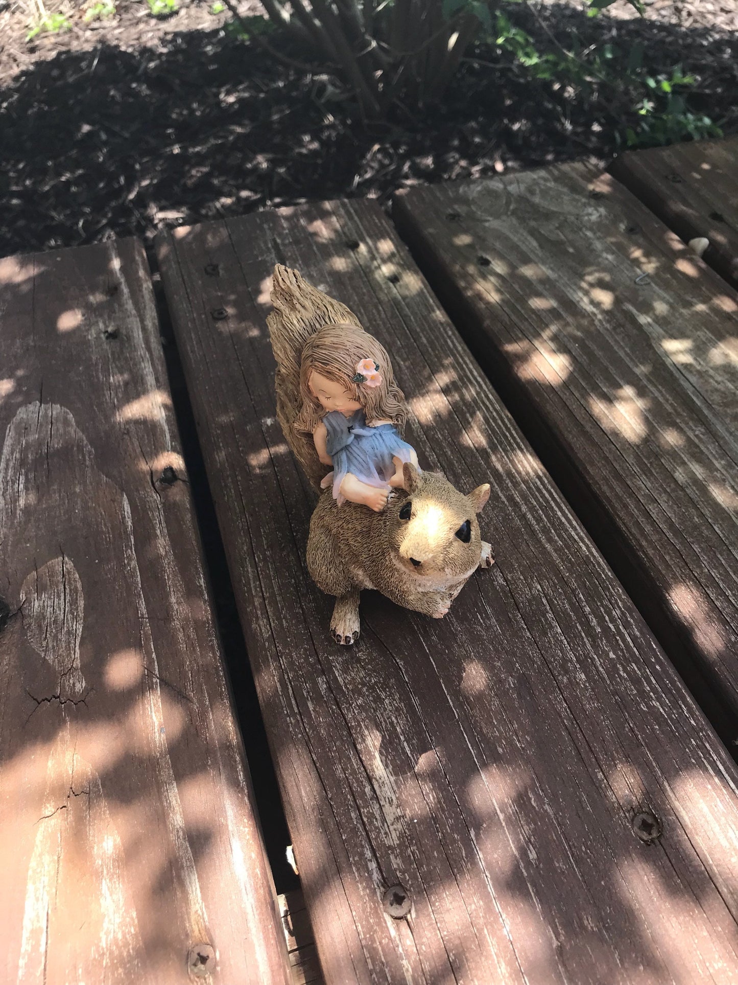 Little sleeping fairy on squirrel, outdoor garden