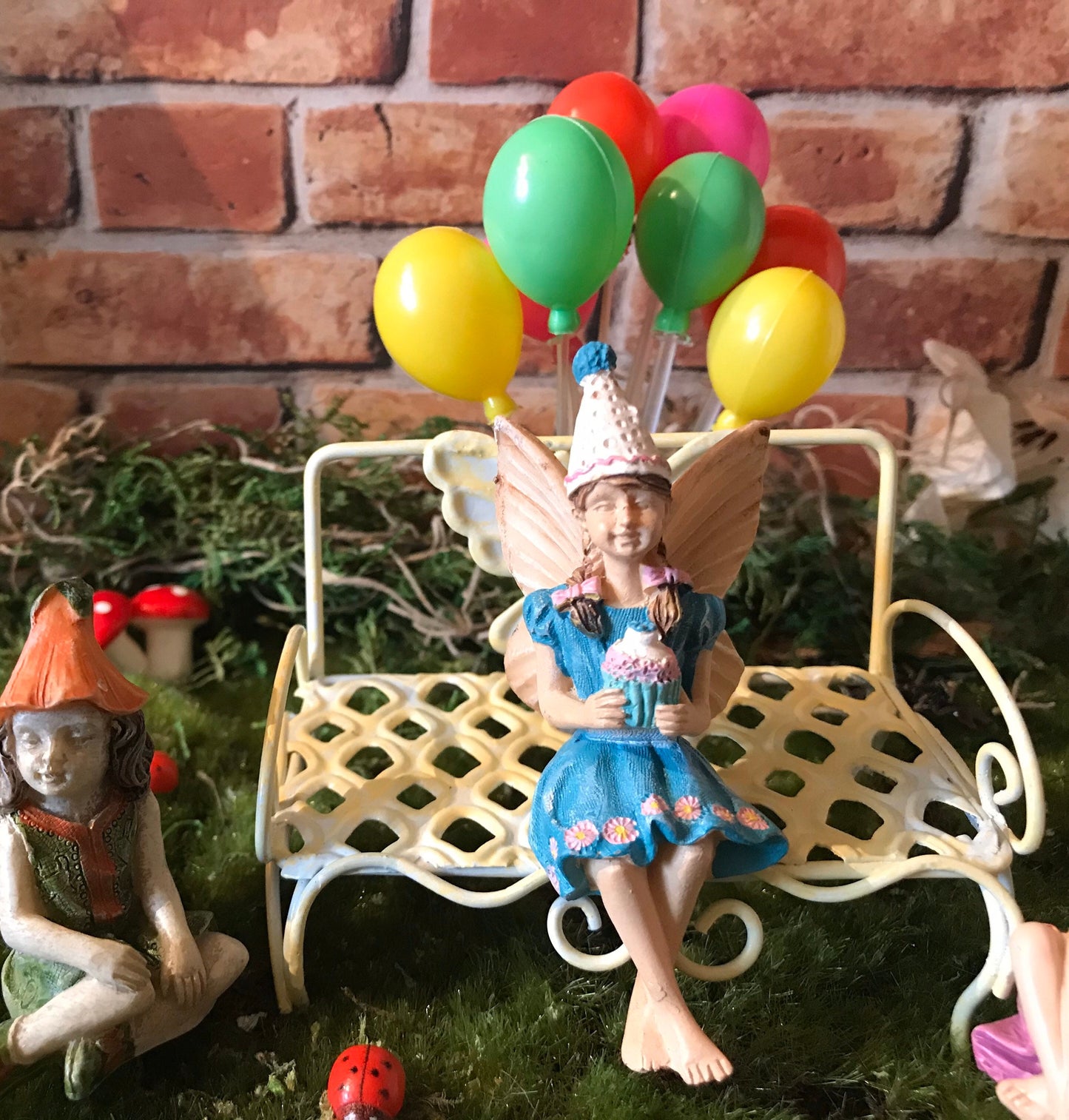 Birthday party girl fairy sitting with her friends holding cupcake