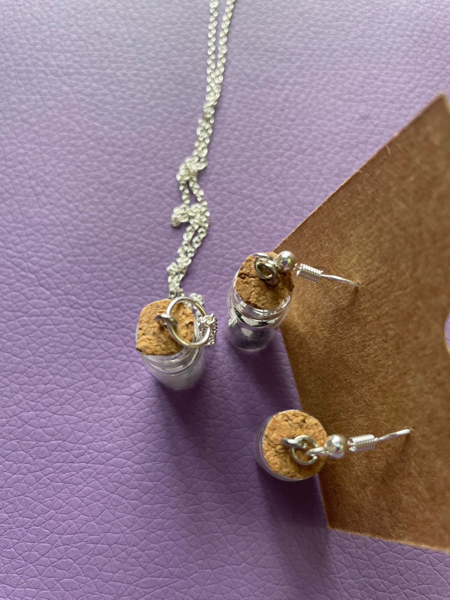 Small bottle earrings and/or necklace filled with a Powerful crystal protection.