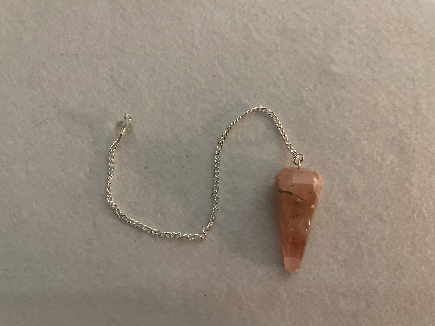This beautiful Rose Quartz Pendulum is 1.65” and with chain is 8”.