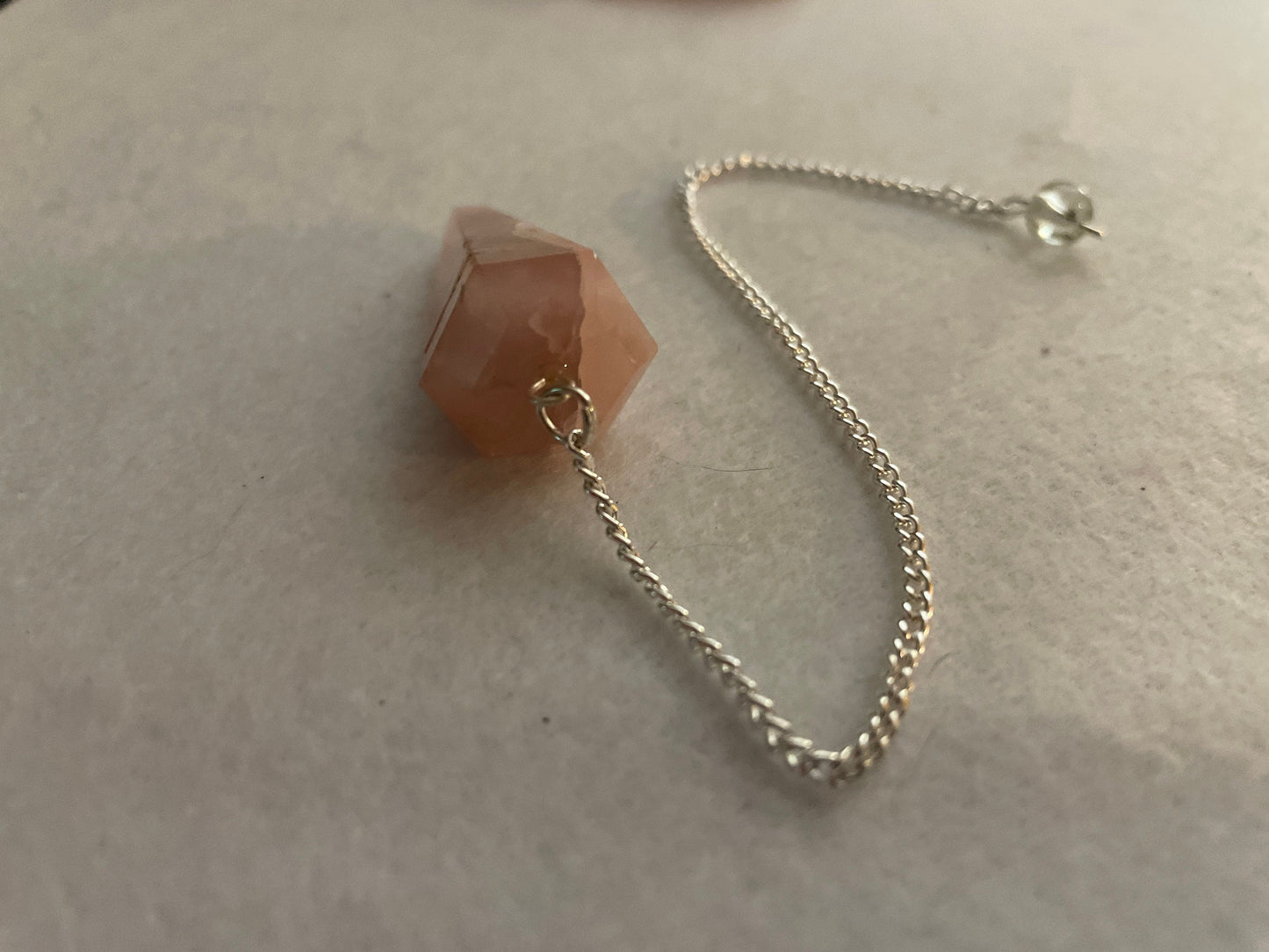 This beautiful Rose Quartz Pendulum is 1.65” and with chain is 8”.