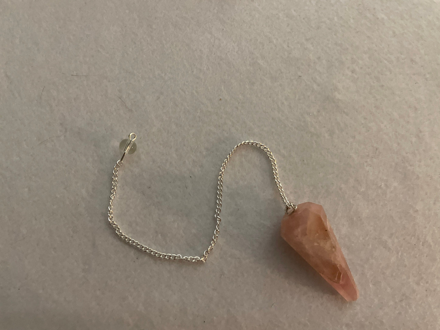 This beautiful Rose Quartz Pendulum is 1.65” and with chain is 8”.