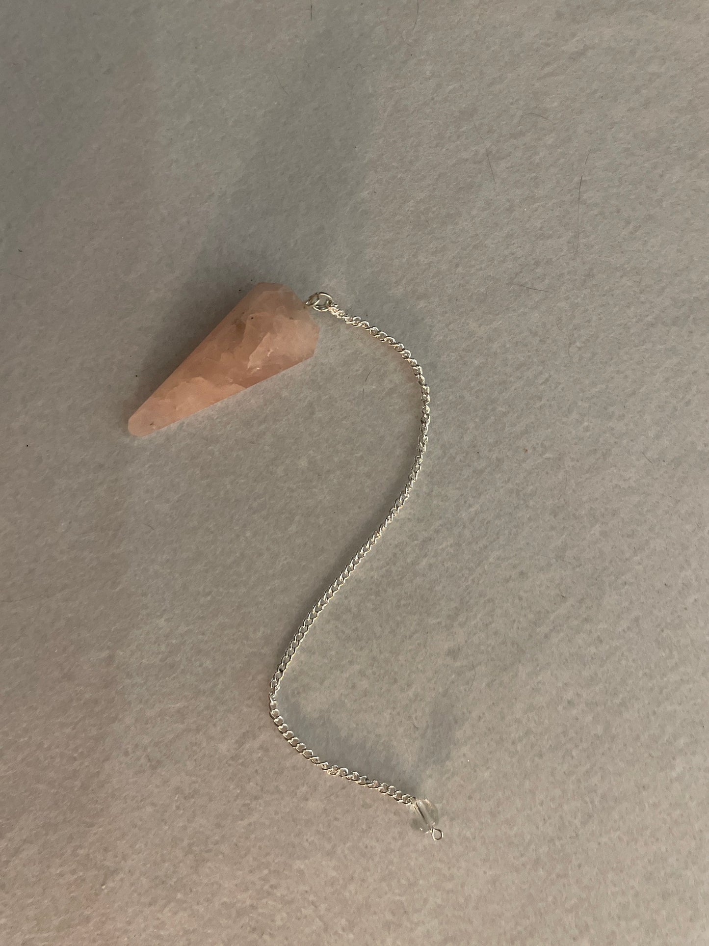 This beautiful Rose Quartz Pendulum is 1.75” and with chain is 8”.