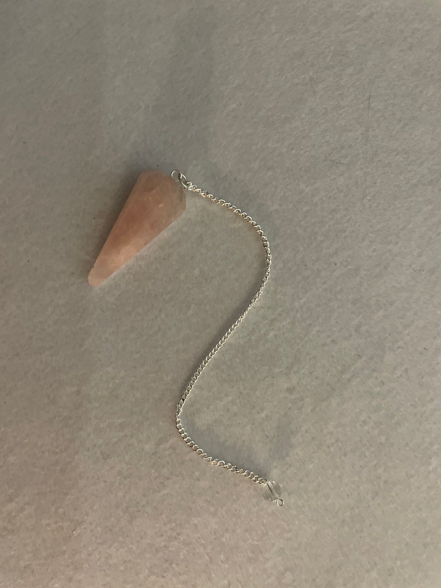 This beautiful Rose Quartz Pendulum is 1.75” and with chain is 8”.