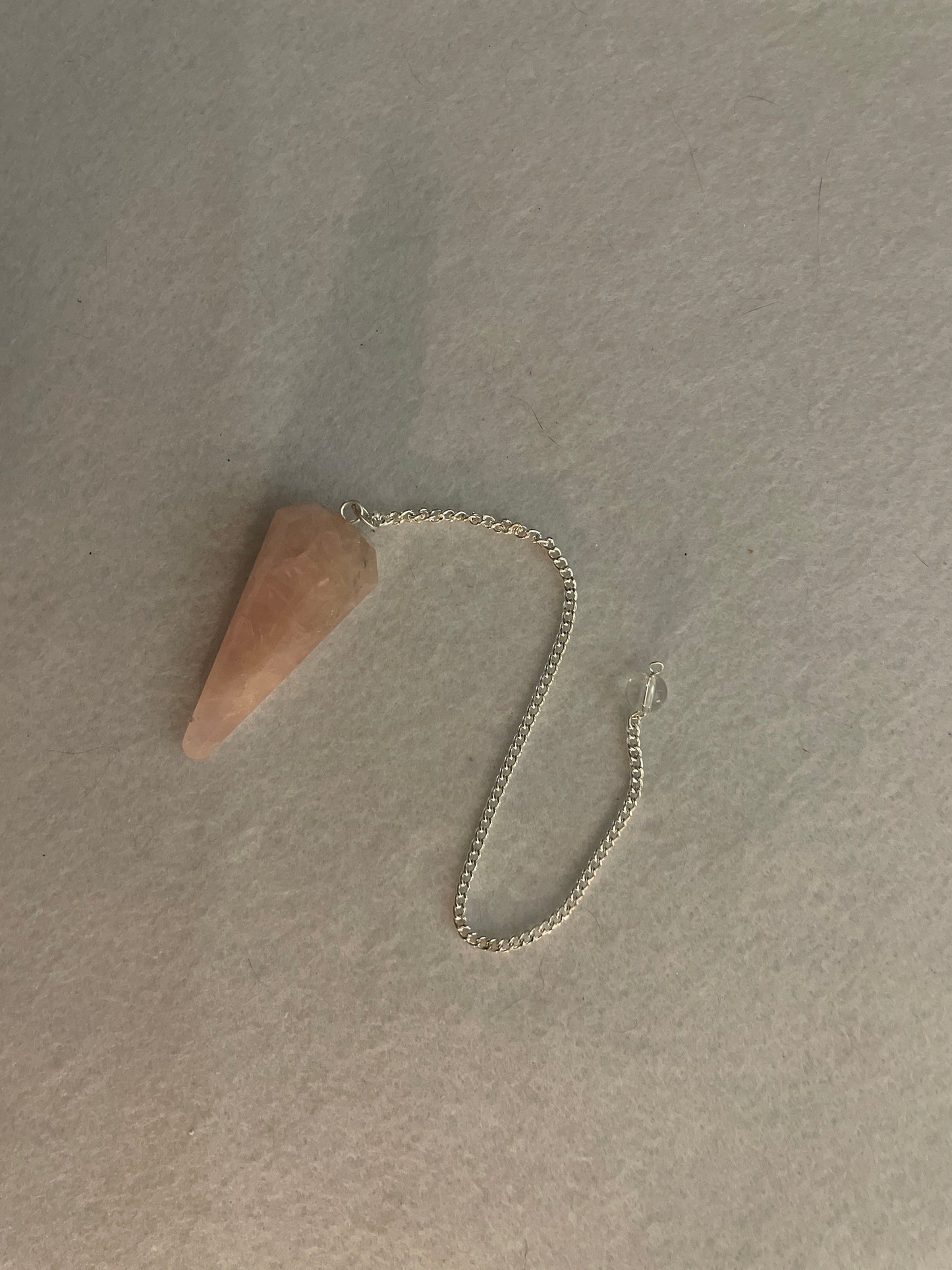 This beautiful Rose Quartz Pendulum is 1.75” and with chain is 8”.