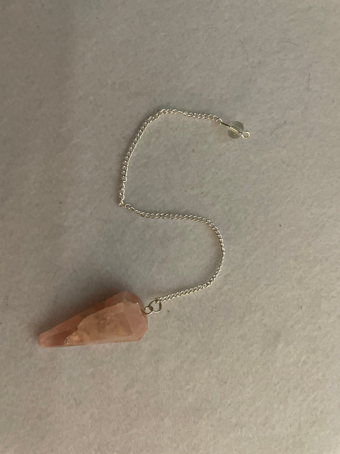 This beautiful Rose Quartz Pendulum is 1.65” and with chain is 8”.