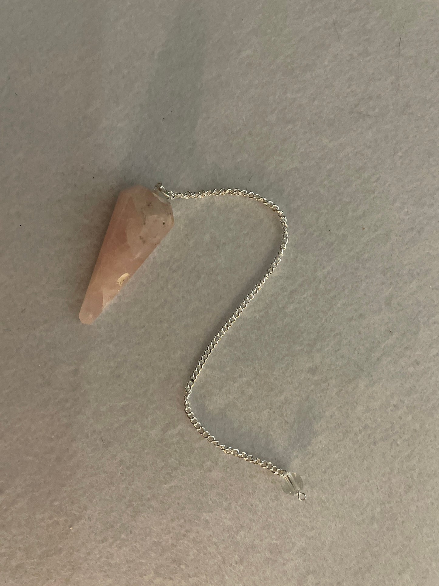 This beautiful Rose Quartz Pendulum is 1.75” and with chain is 8”.