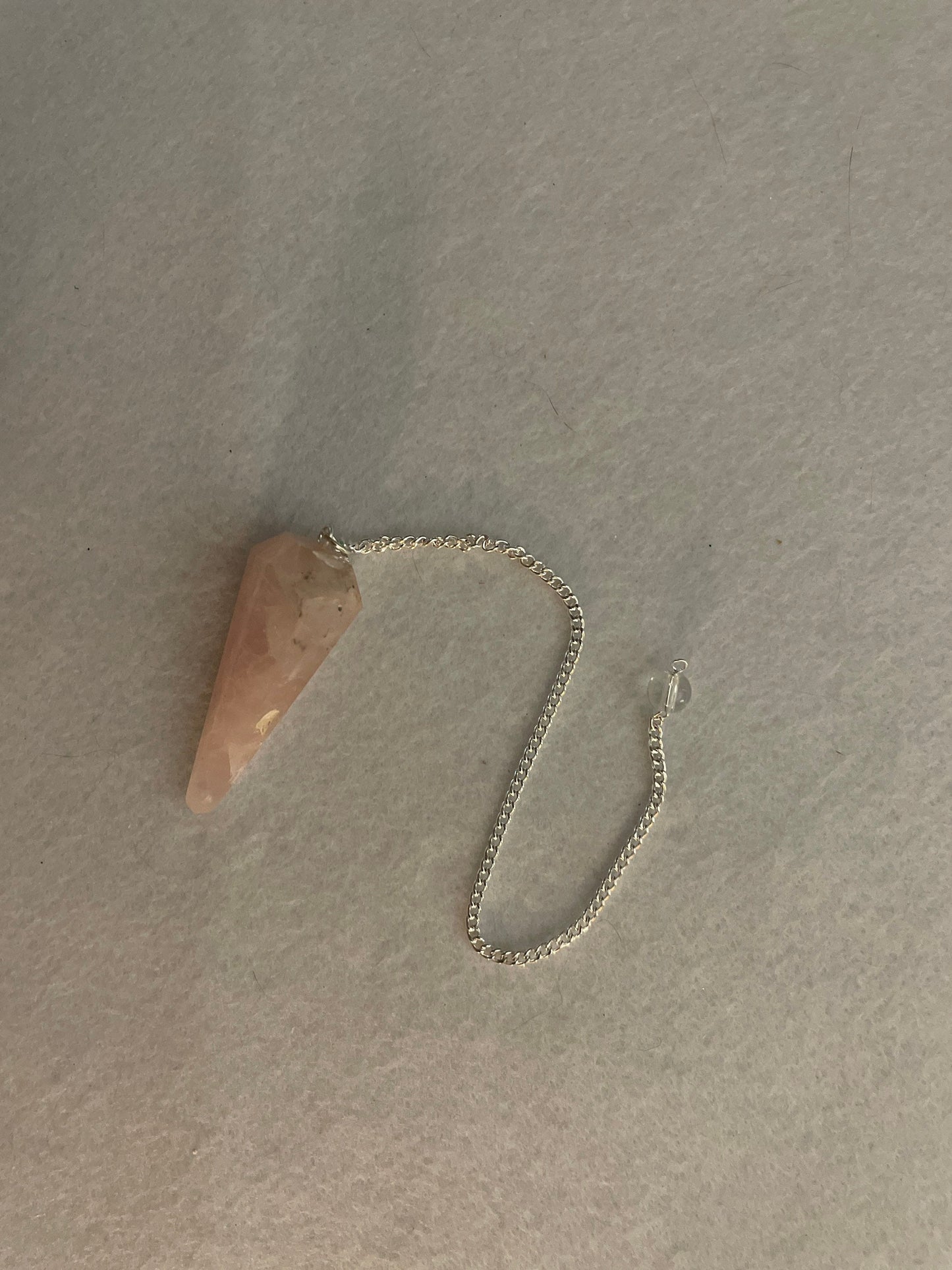 This beautiful Rose Quartz Pendulum is 1.75” and with chain is 8”.