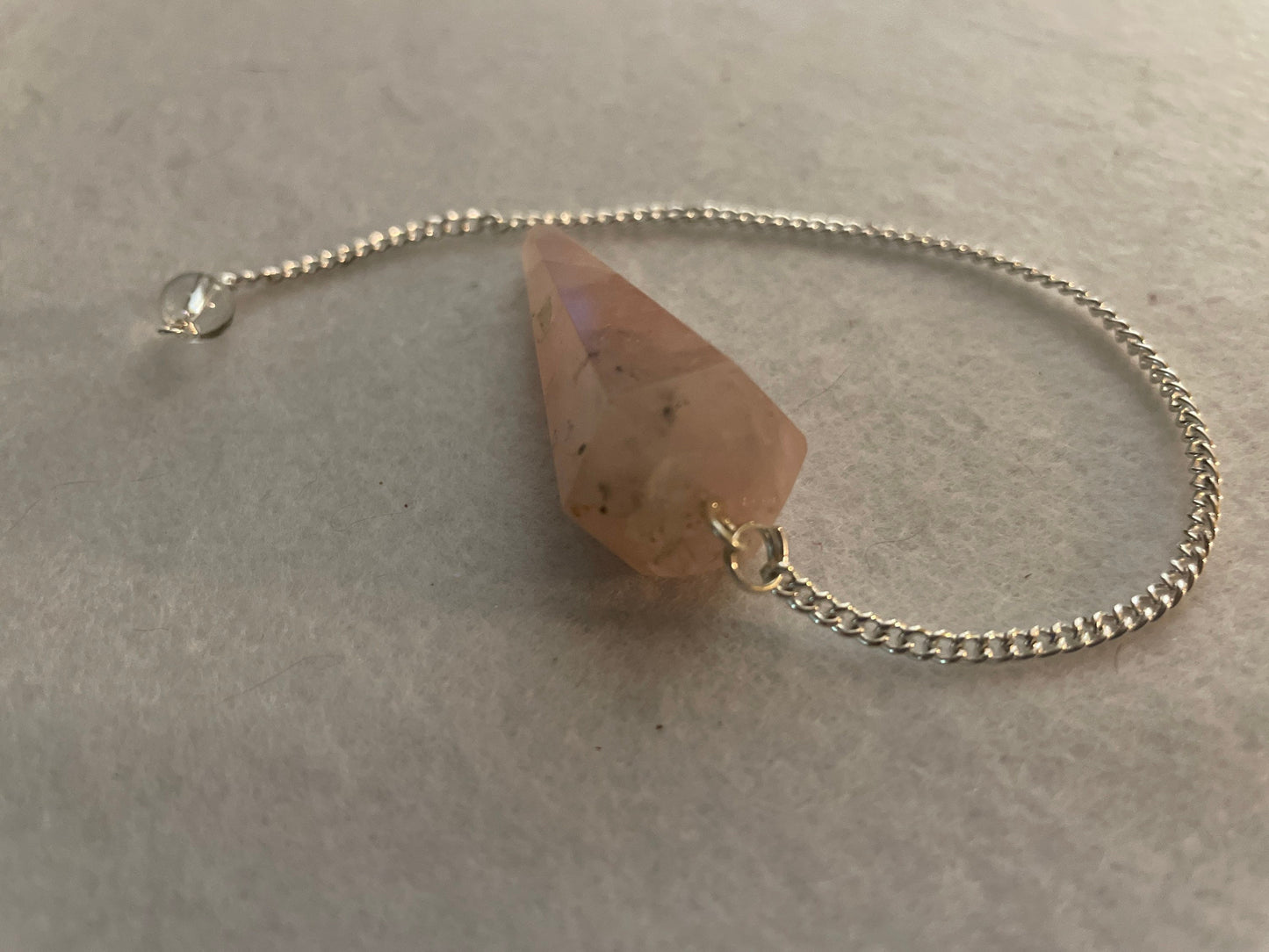 This beautiful Rose Quartz Pendulum is 1.75” and with chain is 8”.