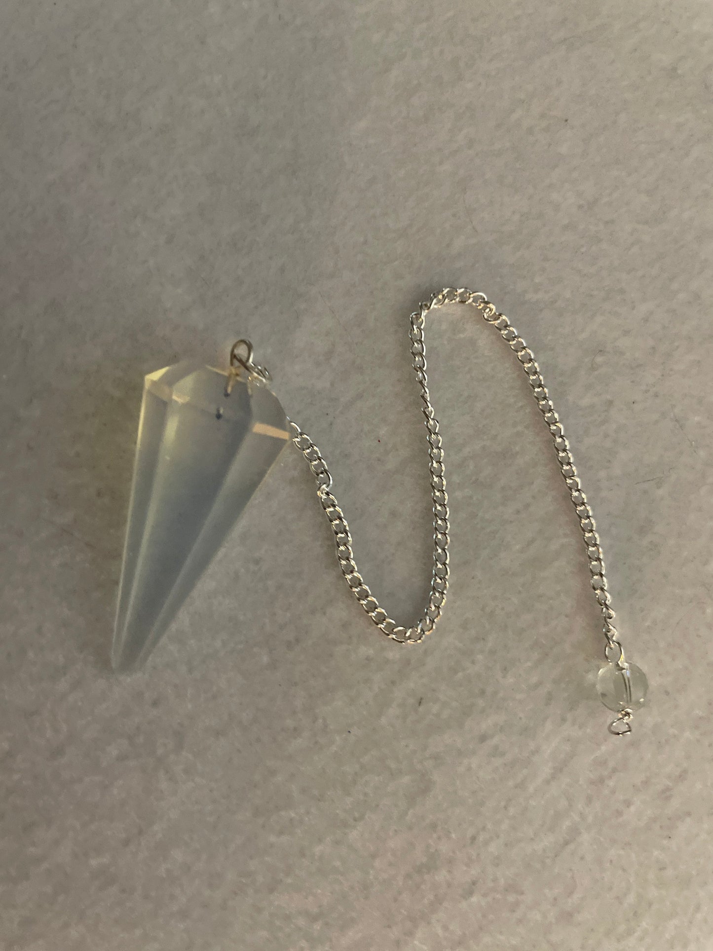 This beautiful  Opalite pendulum is approximately 1.5” and with chain is 8.25”