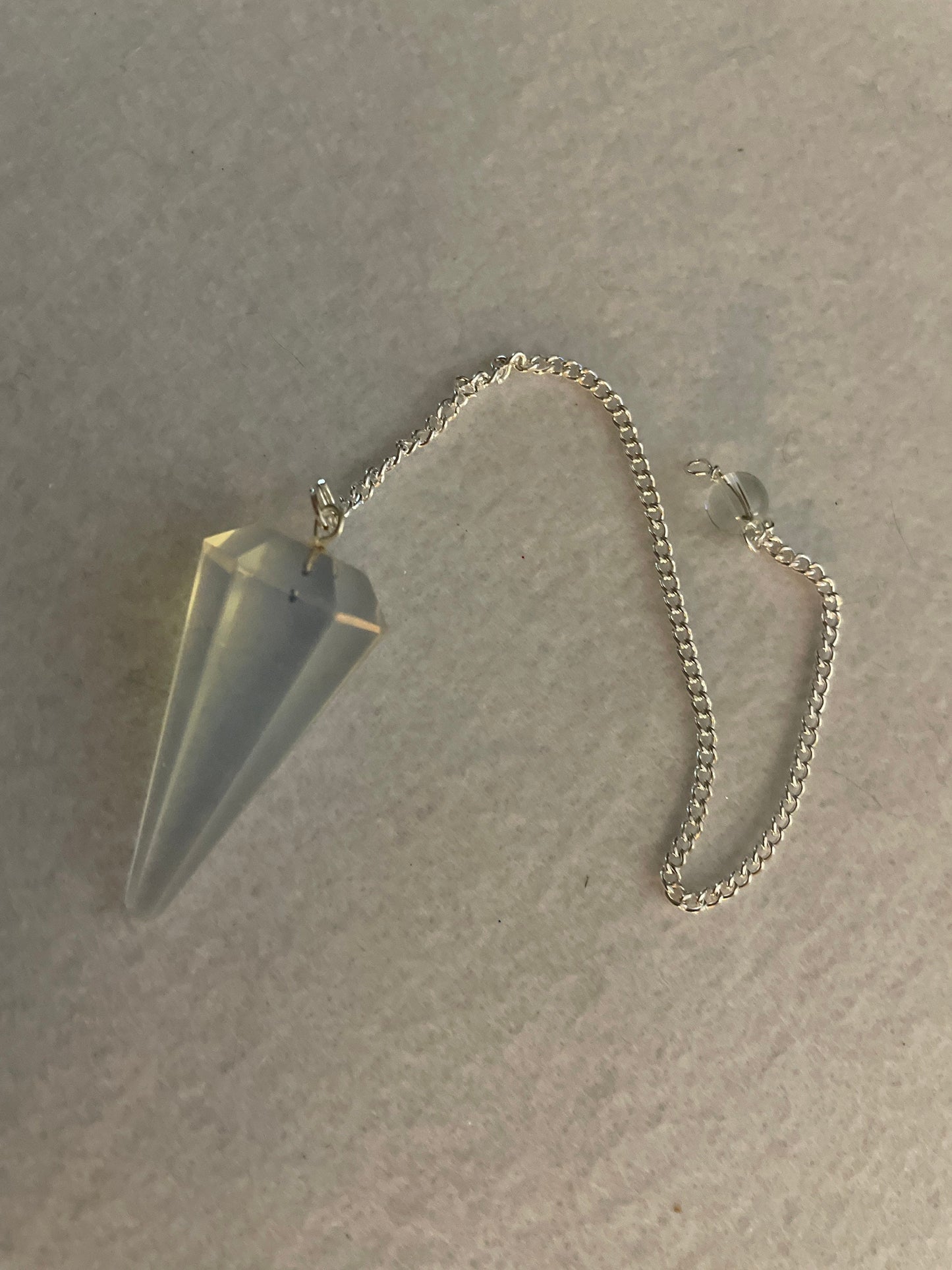 This beautiful  Opalite pendulum is approximately 1.5” and with chain is 8.25”