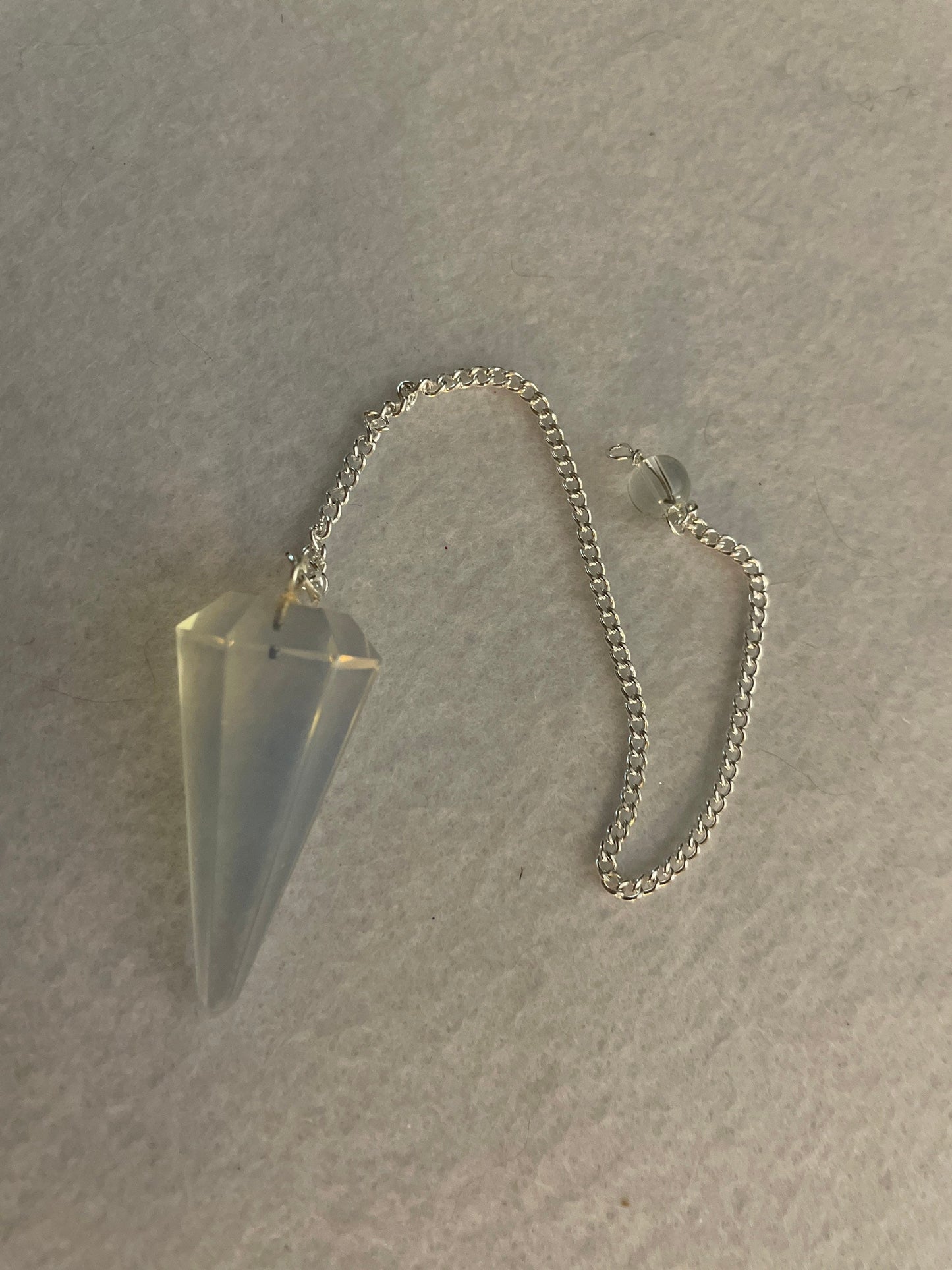 This beautiful  Opalite pendulum is approximately 1.5” and with chain is 8.25”