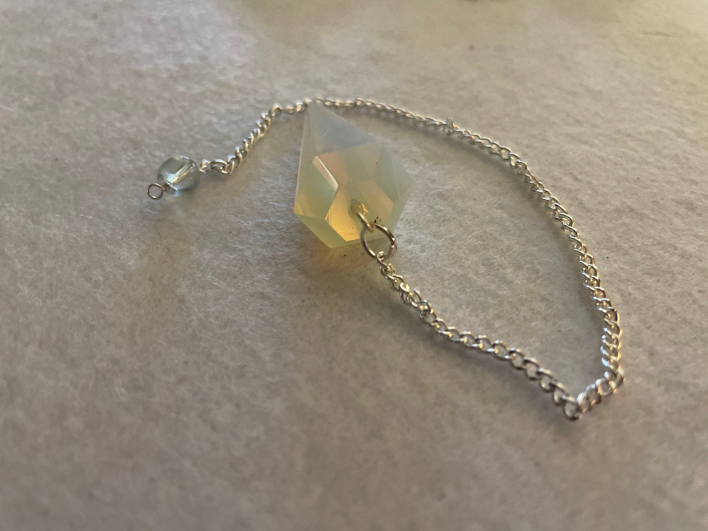 This beautiful  Opalite pendulum is approximately 1.65” and with chain is 8.5”