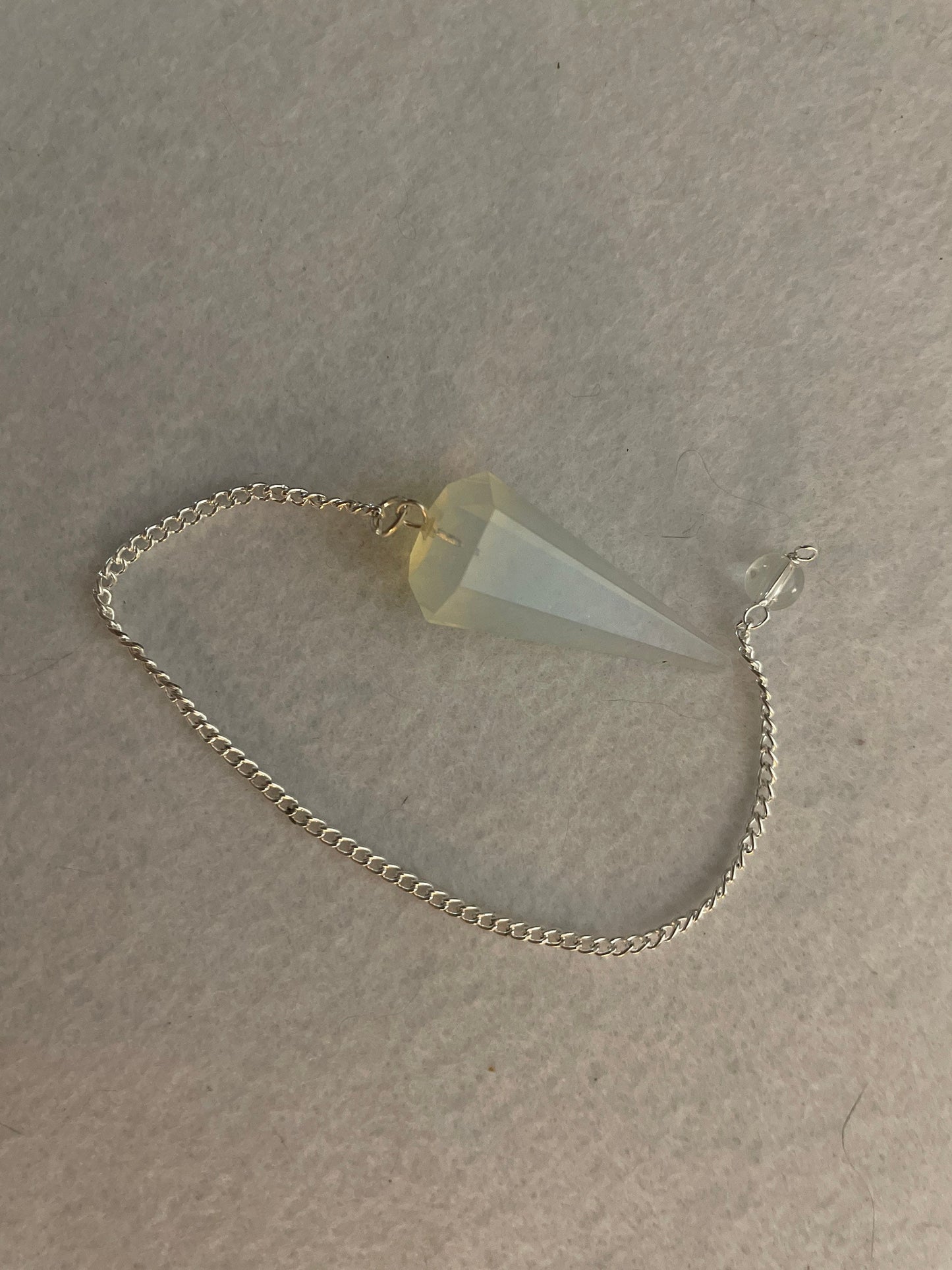 This beautiful  Opalite pendulum is approximately 1.65” and with chain is 8.5”