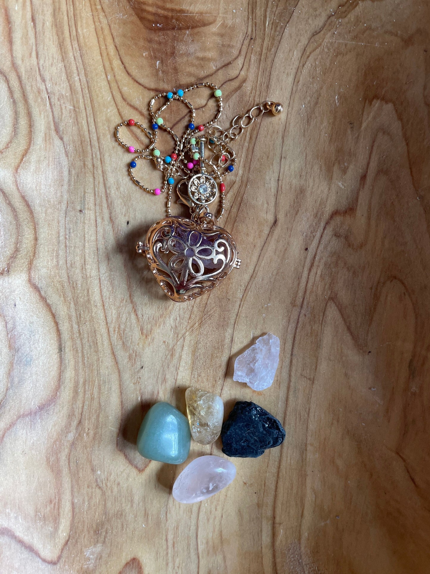 Gold locket filled with crystals on 16+” beaded gold