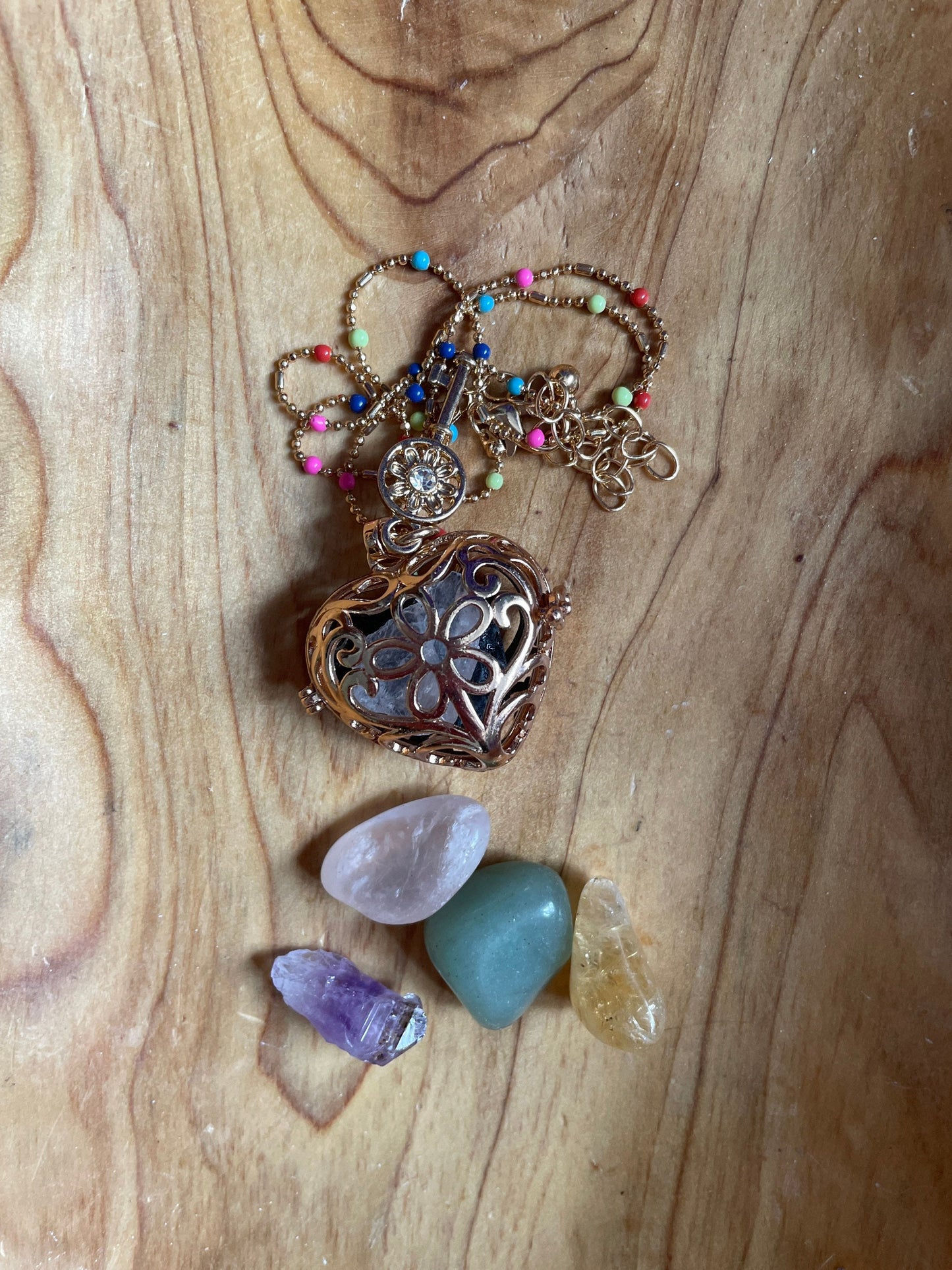 Gold locket filled with crystals on 16+” beaded gold