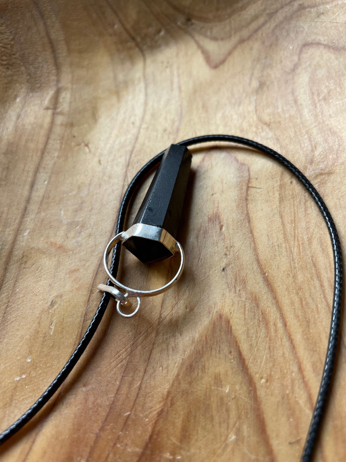 Beautiful black obsidian pendant on a black cord attached with silver wire