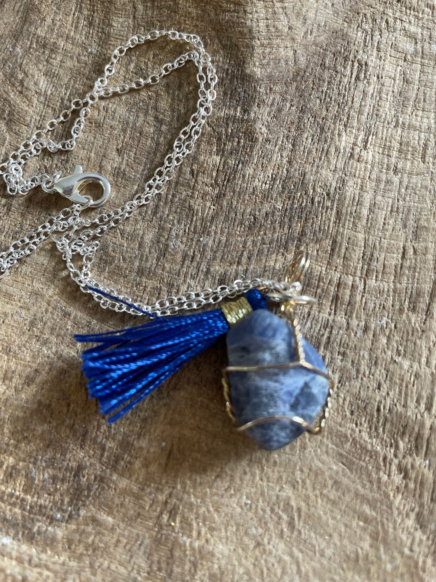 Pretty tumbled Sodalite is wrapped in silver wire is approximately .85” and is attached to a precious silver-plated chain making 16+” chain