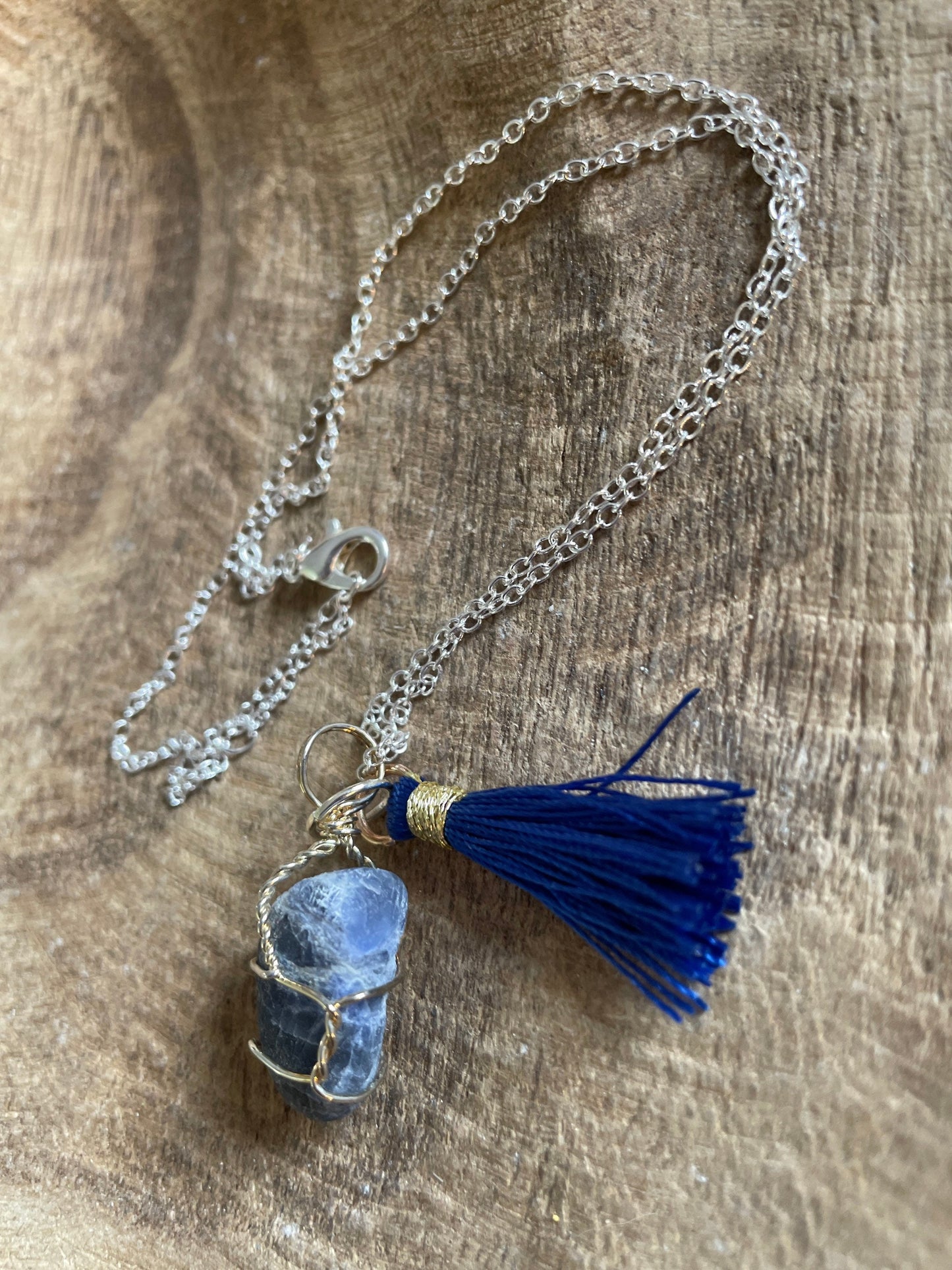 Pretty tumbled Sodalite is wrapped in silver wire is approximately .85” and is attached to a precious silver-plated chain making 16+” chain