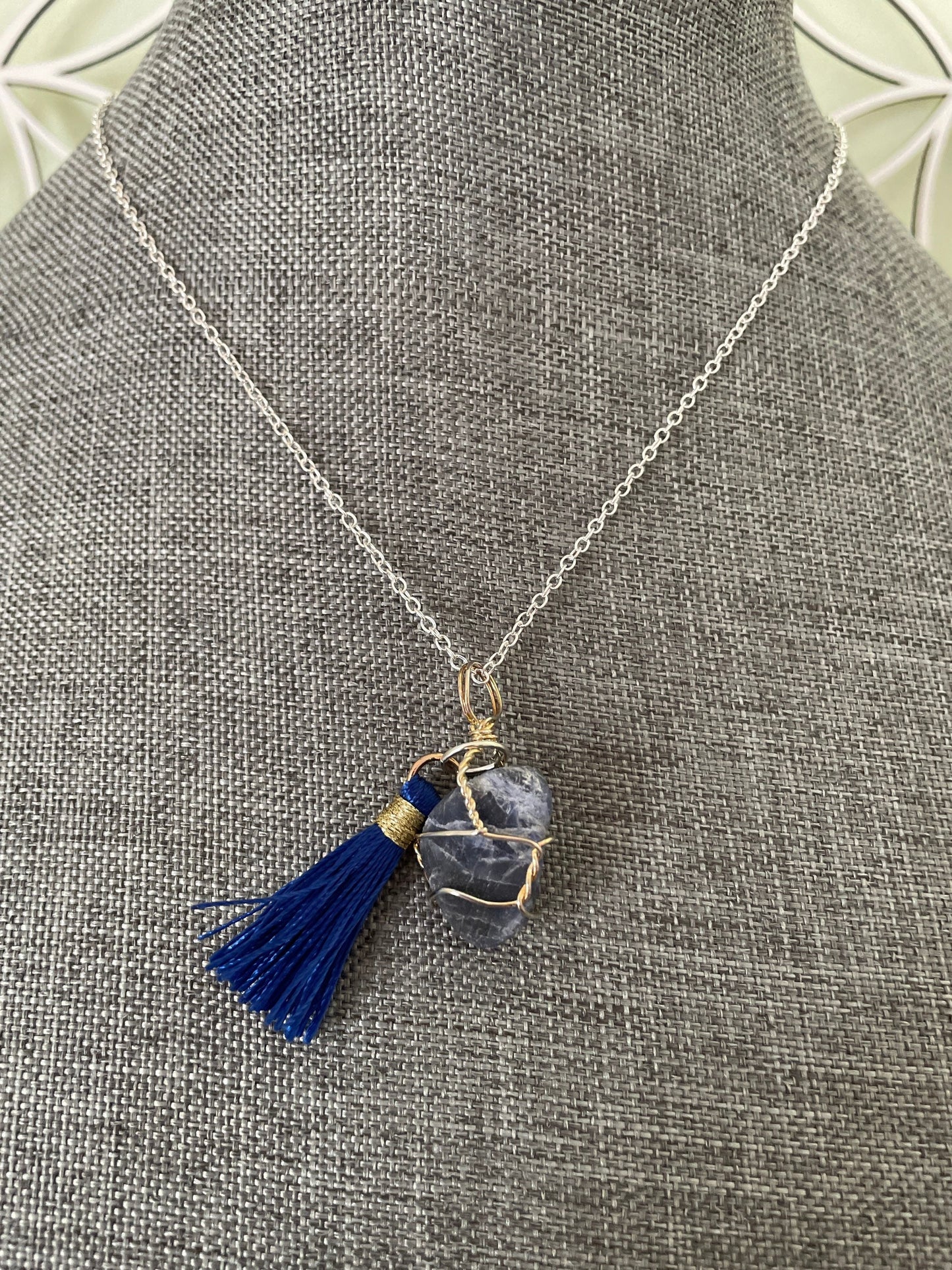 Pretty tumbled Sodalite is wrapped in silver wire is approximately .85” and is attached to a precious silver-plated chain making 16+” chain