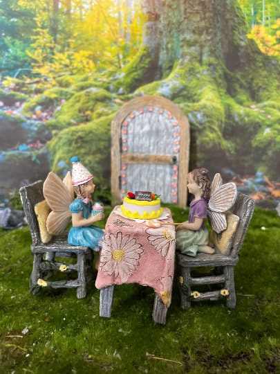 Birthday party girl fairy sitting with her friends holding cupcake