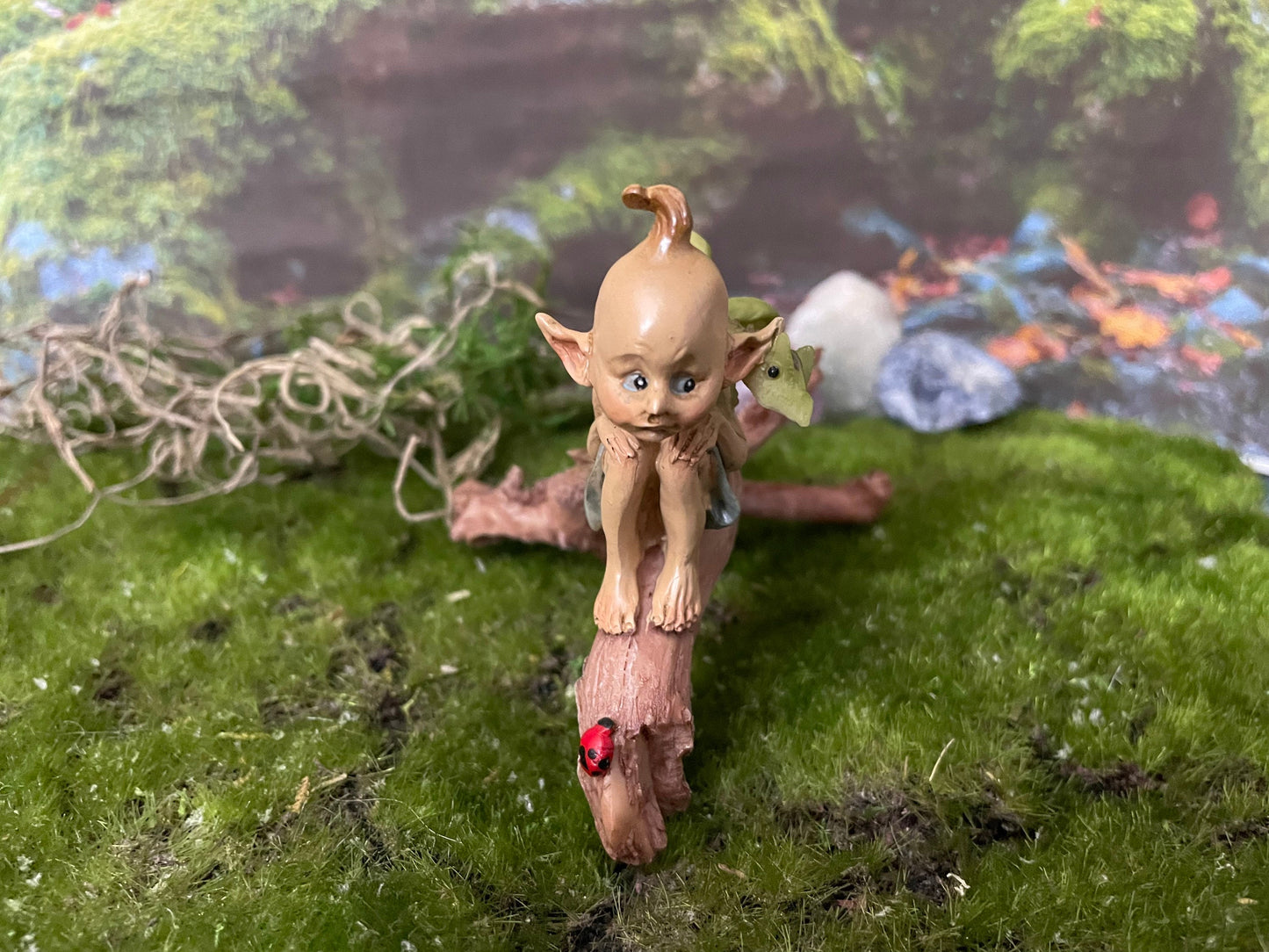 Pixie lovers garden pixie and baby green dragon perching on a log