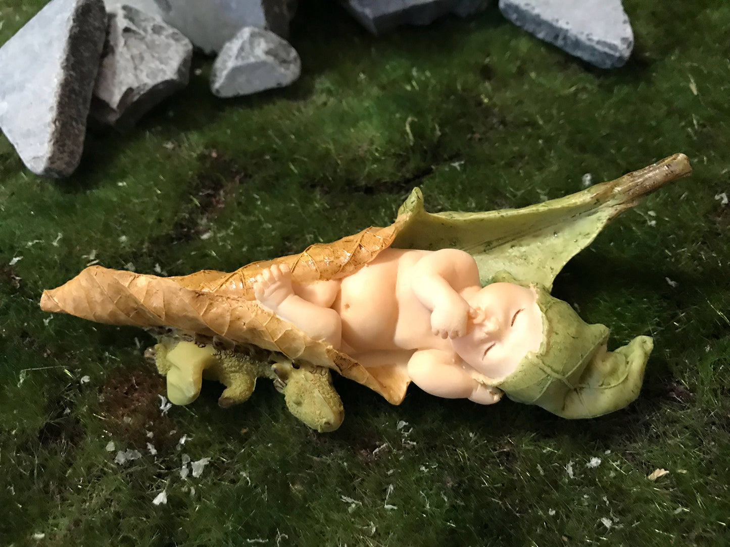 Baby Fairy laying on a leaf with a baby dragon curled up next to her.
