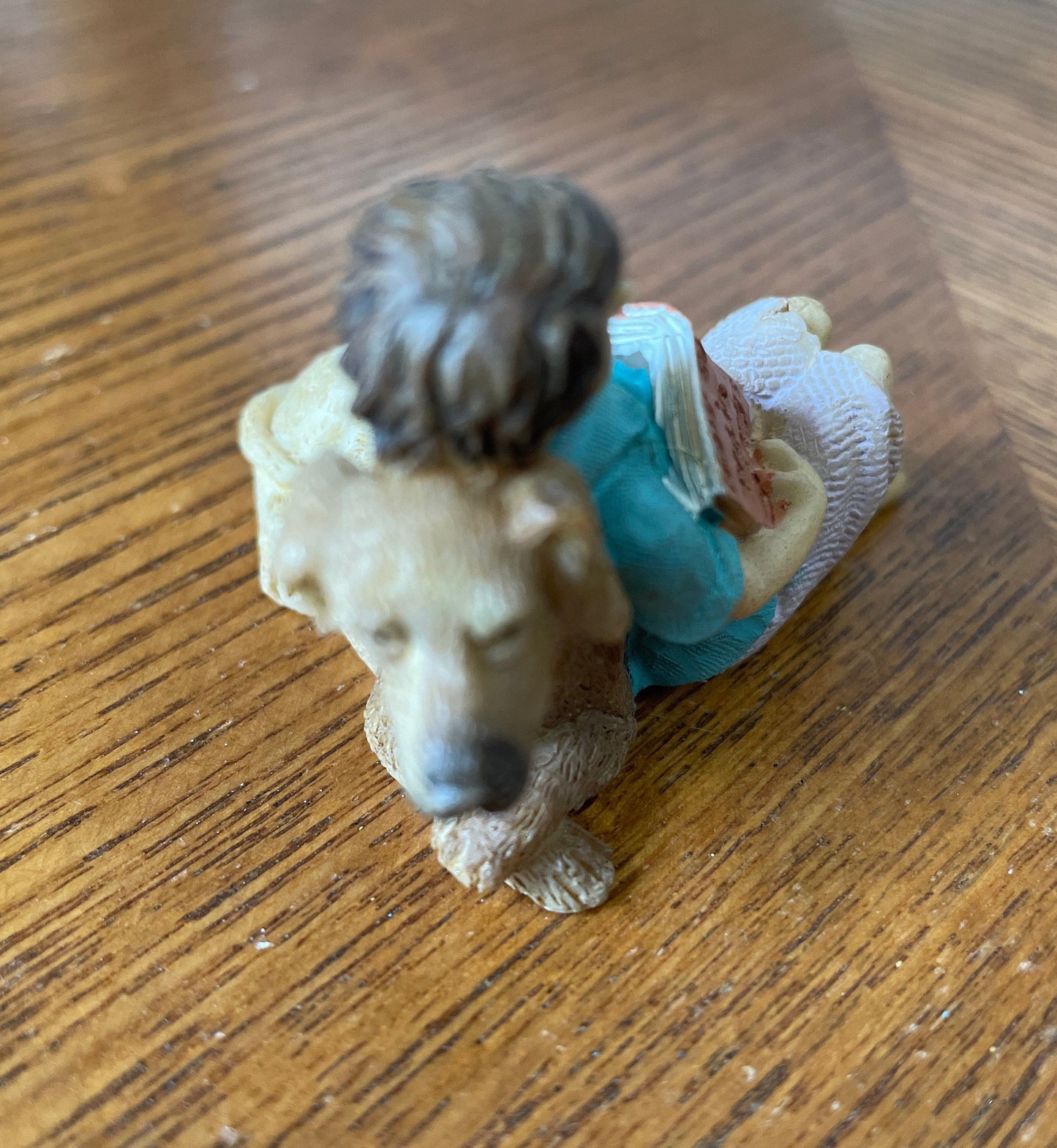 Fairy boy figurine relaxing with his dog while reading a book
