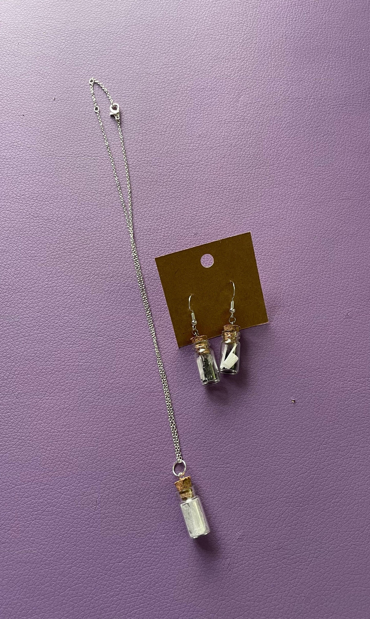 Small bottle earrings and/or necklace filled with a Powerful crystal protection.
