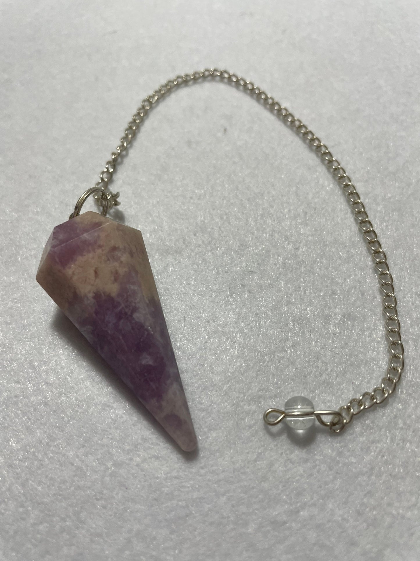 This magnificent pink and purple Lepidolite Pendulum is  1.75” and with chain is 9”.