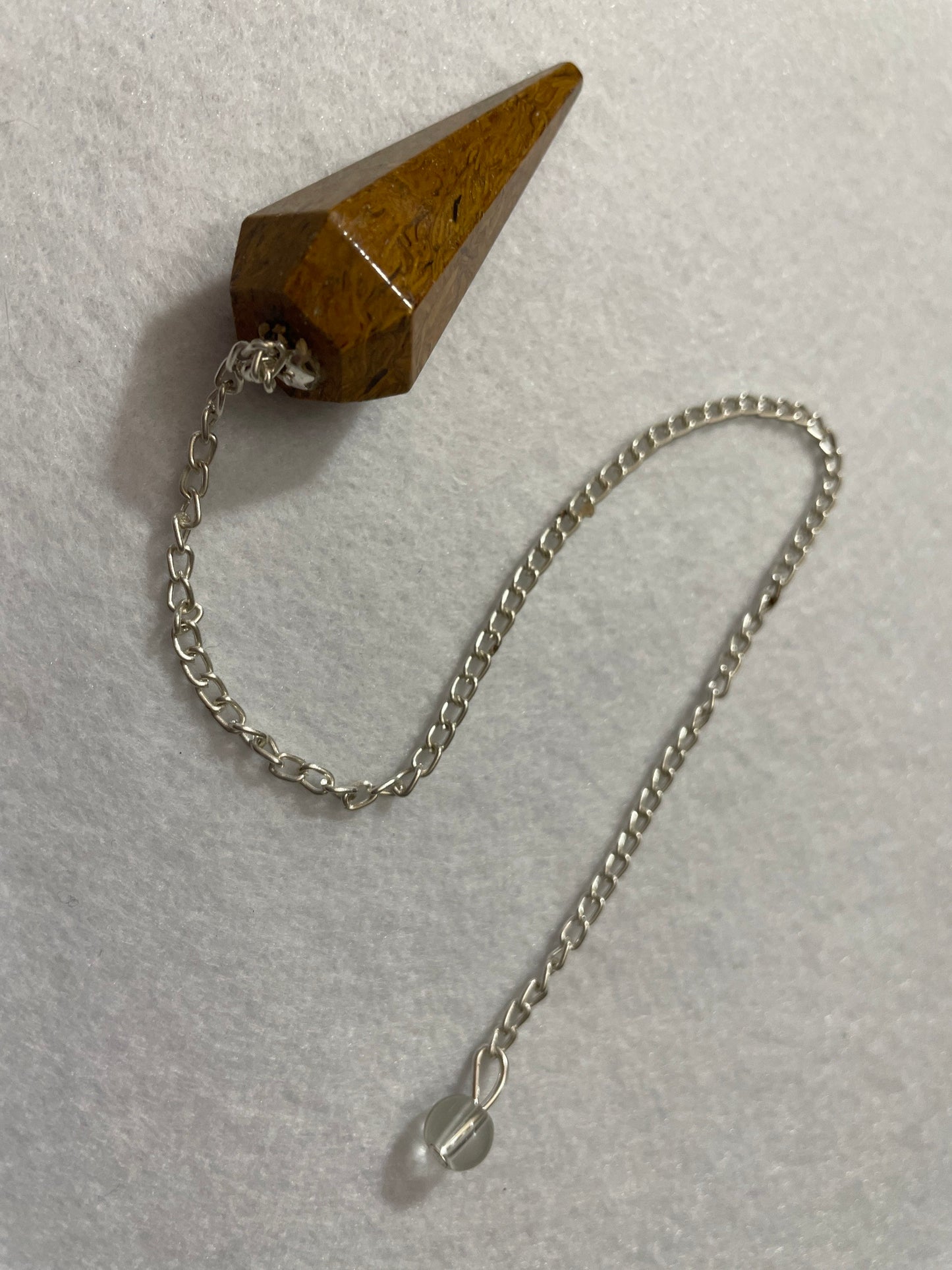 This beautiful Yellow Jasper Pendulum is 1.75” with the chain it is approximately 10.5”.