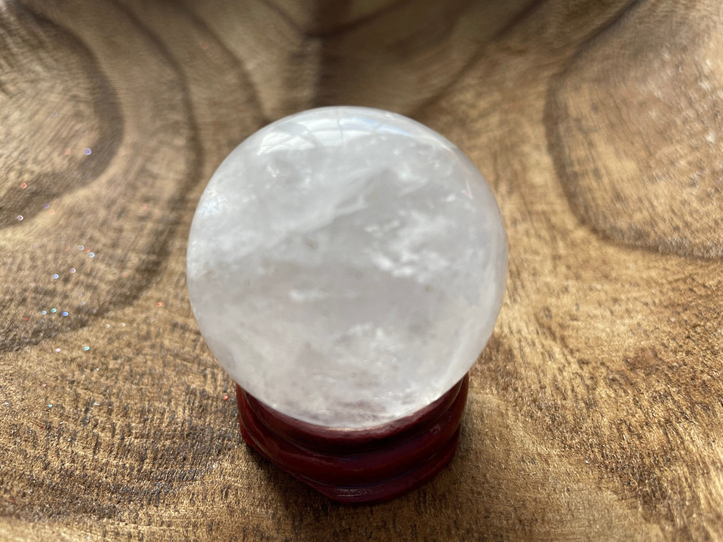 Crystal Clear Quartz crystal ball/sphere is 3.2 oz with the wooden stand.