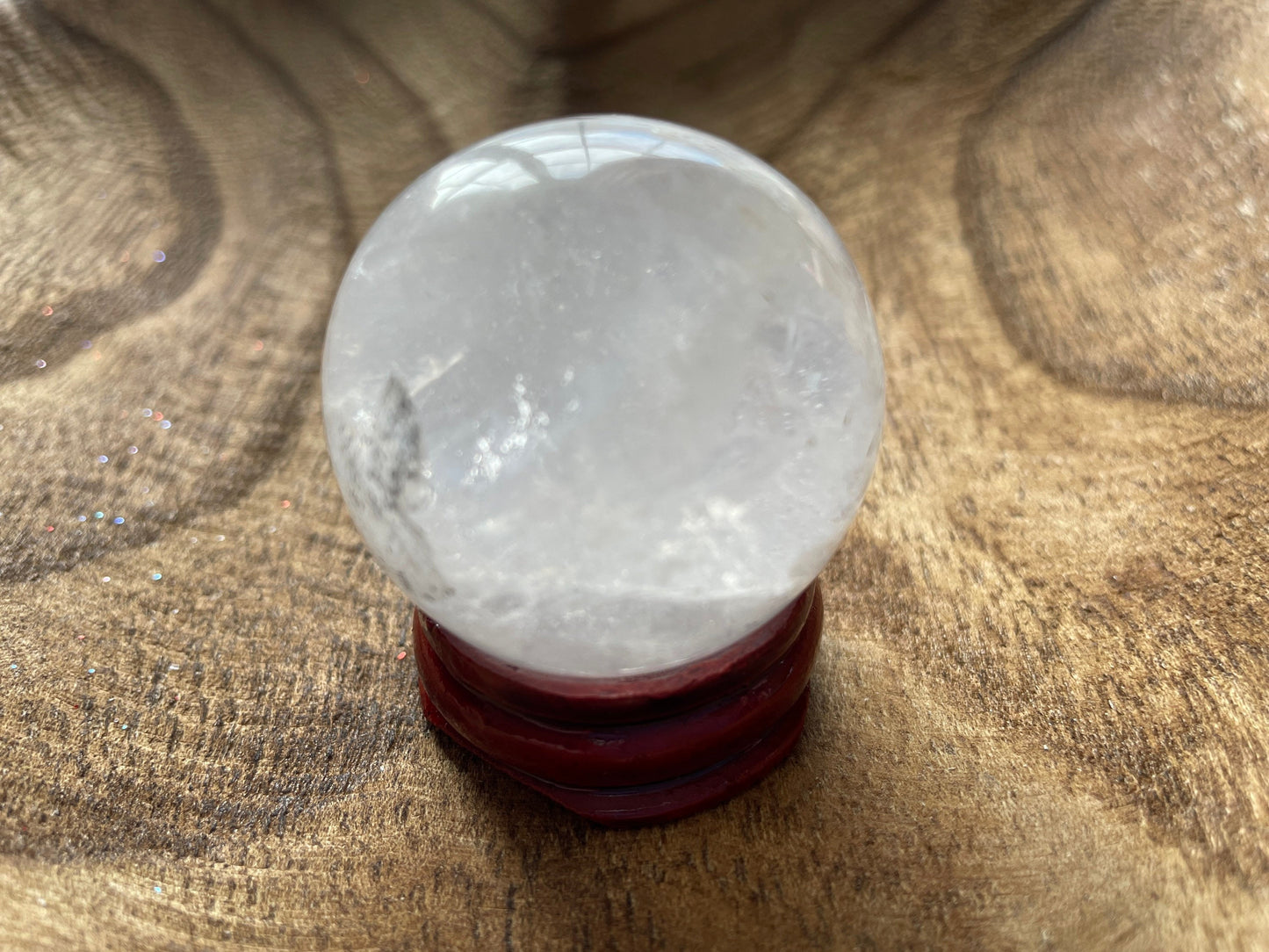 Crystal Clear Quartz crystal ball/sphere is 3.2 oz with the wooden stand.