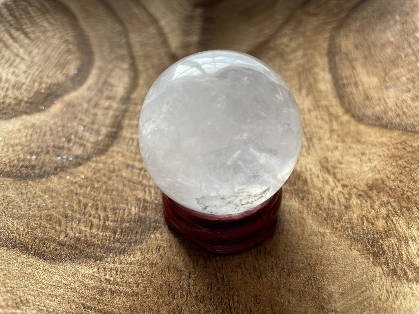 Crystal Clear Quartz crystal ball/sphere is 3.2 oz with the wooden stand.