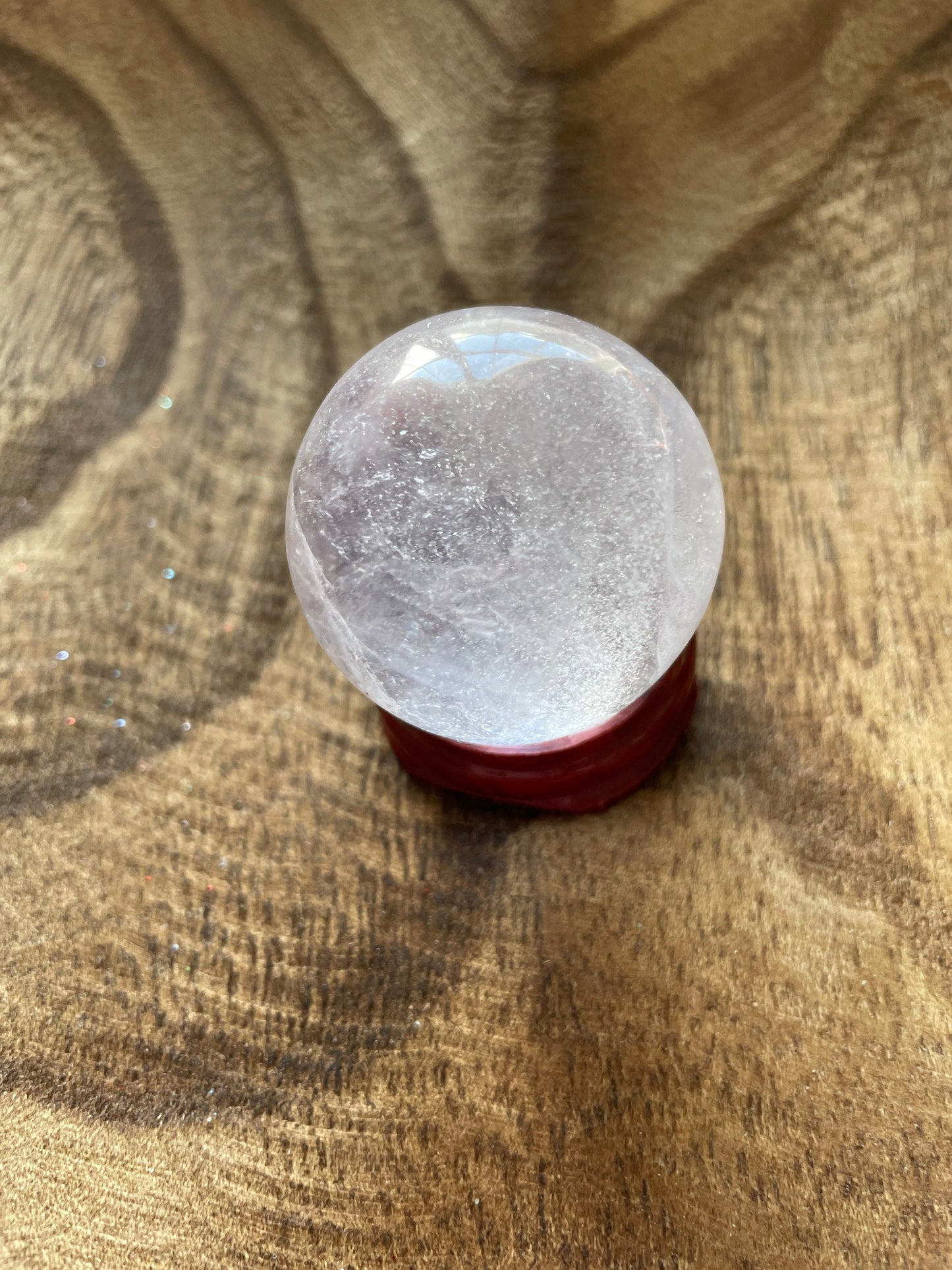 Crystal Clear Quartz crystal ball/sphere is 2.7 oz with the wooden stand.