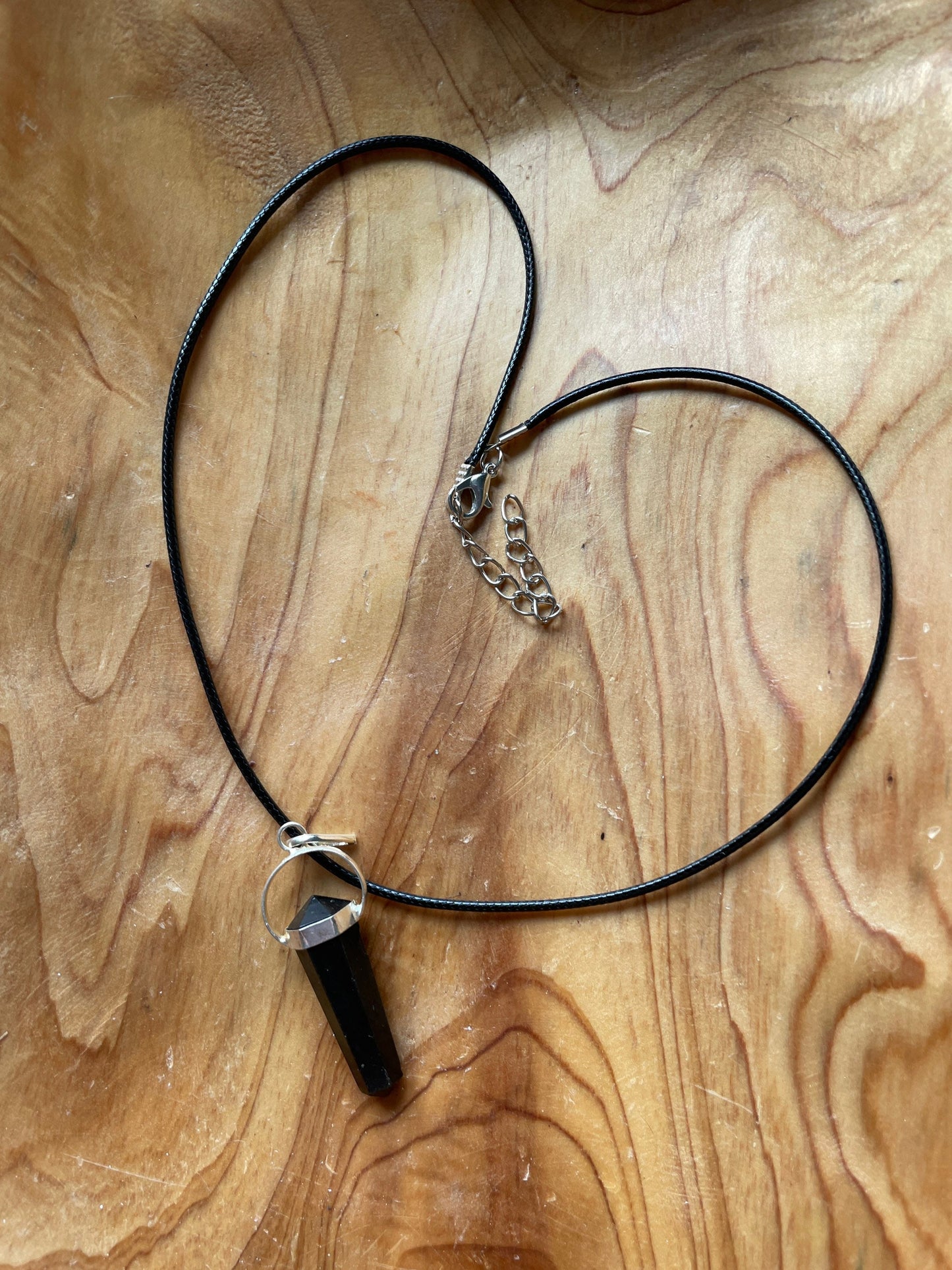 Beautiful black obsidian pendant on a black cord attached with silver wire