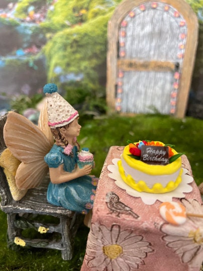 Birthday party girl fairy sitting with her friends holding cupcake